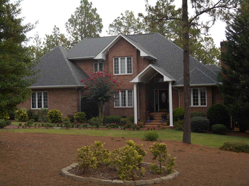Brick house with custom roofing laid down and designed by Creed & Garner Roofing Company Inc. in Aberdeen, NC.