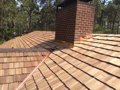 Custom shingles laid down and designed around a brick chimney by Creed & Garner Roofing Company in Aberdeen, NC.